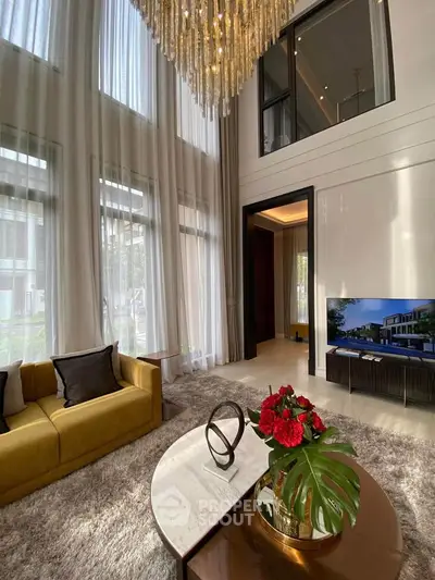 Luxurious living room with high ceilings, elegant chandelier, and modern decor in a sophisticated home.