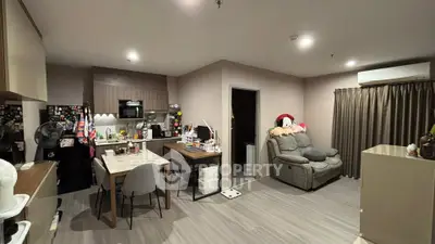 Modern living room with open kitchen, cozy seating, and stylish decor in a contemporary apartment.