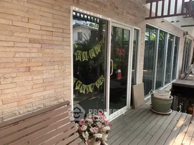 Charming patio with sliding glass doors and festive decor, perfect for outdoor relaxation.