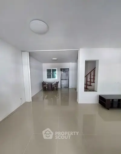 Spacious open-plan living area with modern dining set and sleek tiled flooring.