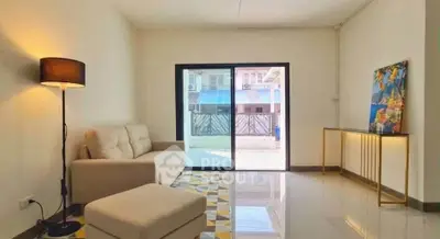 Spacious living room with modern decor and large sliding glass doors leading to a balcony.