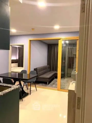 Modern apartment interior with open living and dining area, featuring sleek furniture and ambient lighting.