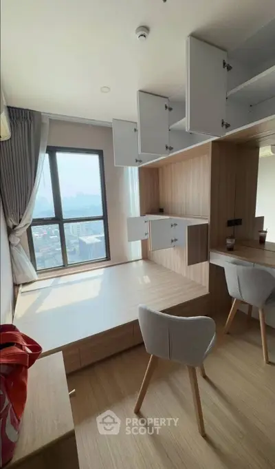 Modern study room with built-in storage and city view, featuring sleek wooden finishes and natural light.