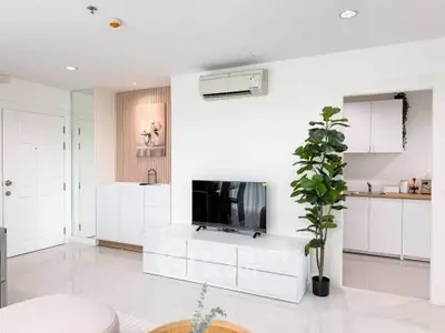 Modern living room with sleek white furniture and open kitchen layout