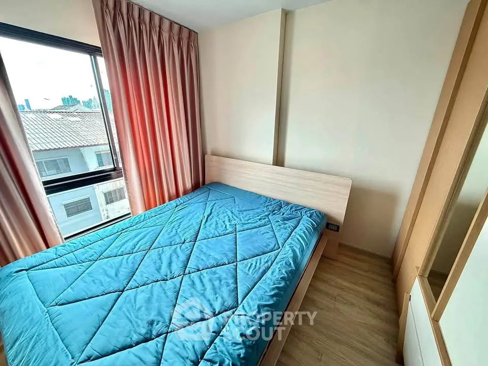 Cozy bedroom with large window and modern furnishings in a stylish apartment.