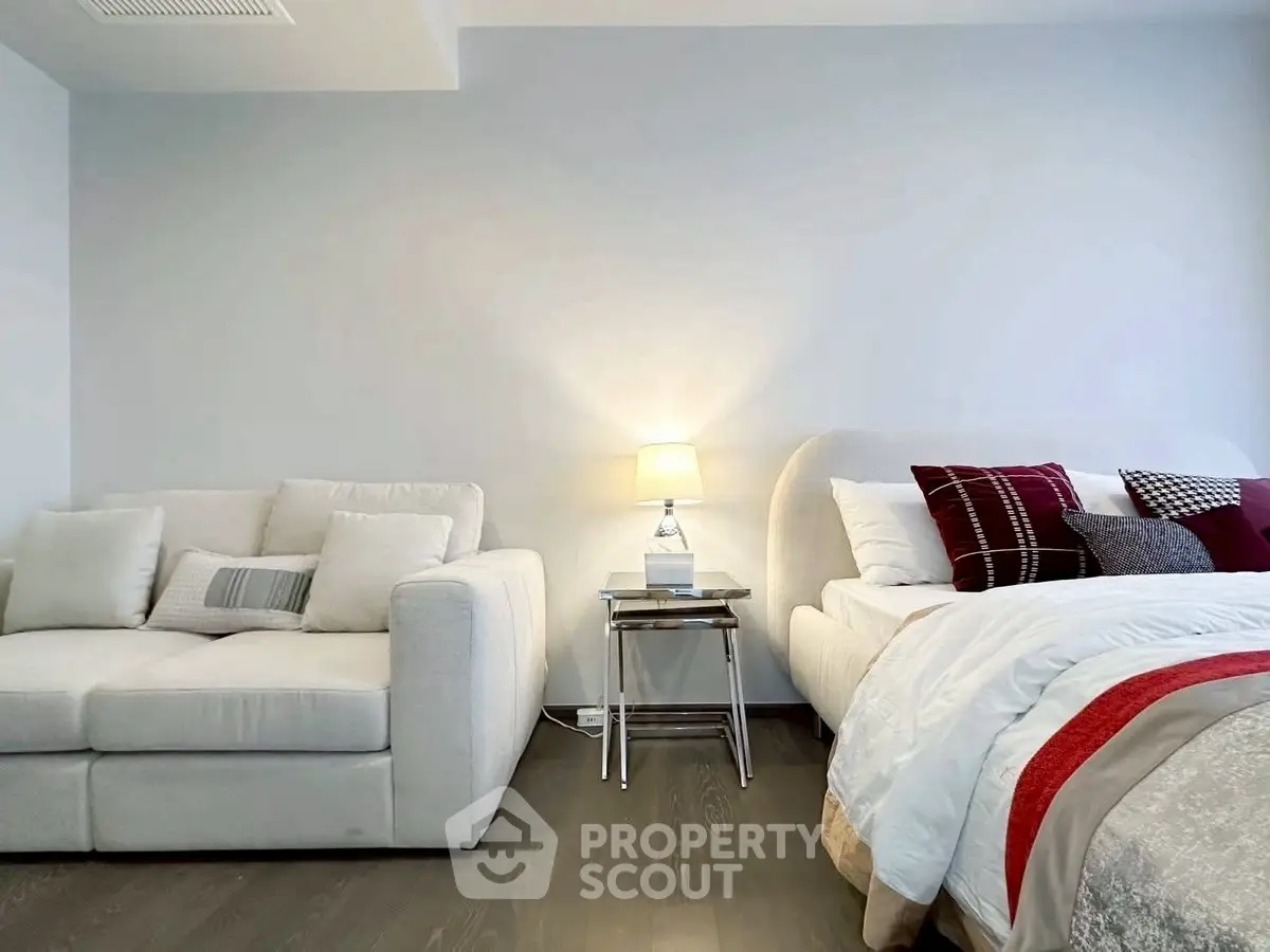 Modern bedroom with cozy bed and stylish sofa, perfect for relaxation and comfort.