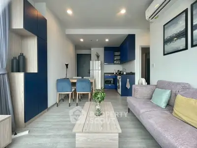 Modern living room with open kitchen, stylish decor, and cozy seating area in a contemporary apartment.