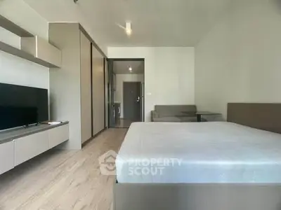 Modern studio apartment with sleek design and ample natural light, featuring a cozy living area and contemporary furnishings.