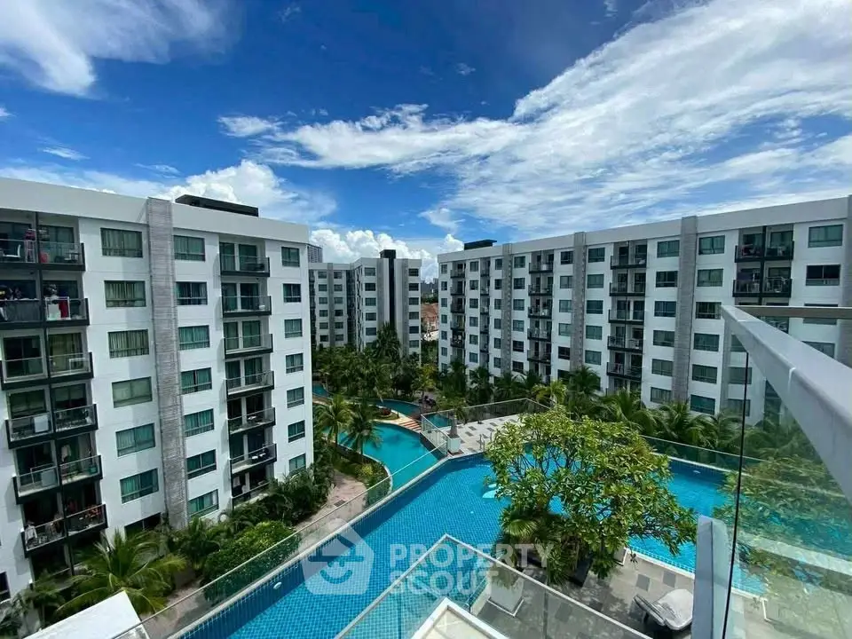 Luxurious residential complex with stunning pool and lush greenery view.