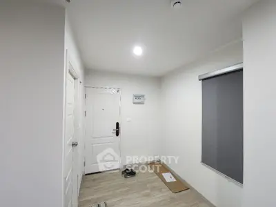 Minimalist apartment entrance with white door and wooden flooring