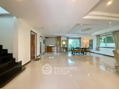 Spacious open-plan living room with modern decor and large windows for natural light.
