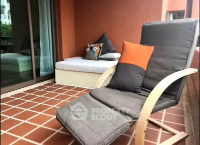 Charming balcony with cozy seating and terracotta tiles, perfect for relaxation.
