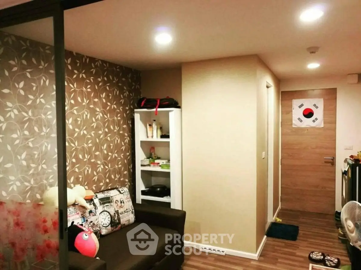 Cozy living room with stylish decor and modern lighting in a compact apartment.