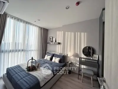 Modern bedroom with elegant decor and natural light, featuring a cozy bed and stylish vanity.