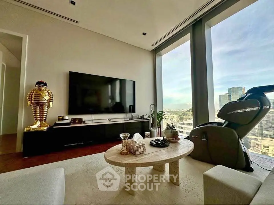 Luxurious living room with stunning city view, modern decor, and large TV setup.