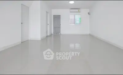 Spacious empty room with glossy white tiles and air conditioning