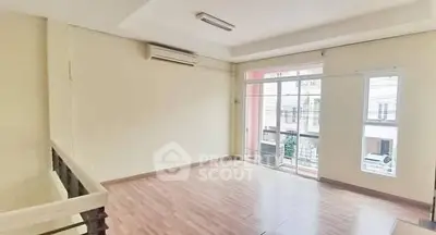 Spacious living room with large windows and modern flooring in a bright apartment.