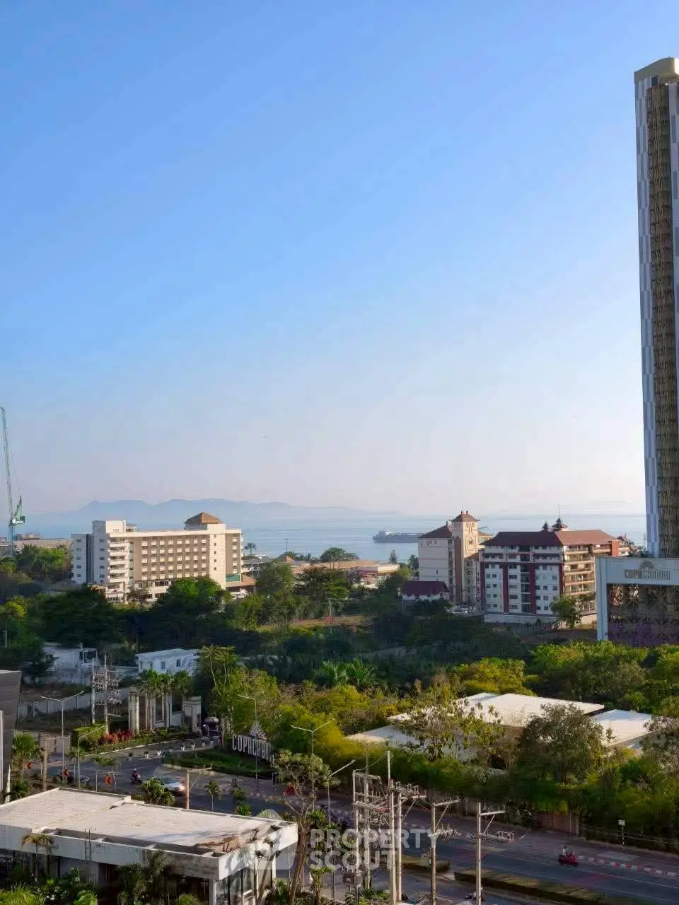 Stunning cityscape view with ocean backdrop and modern high-rise buildings.