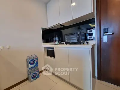 Compact kitchen with sleek cabinets and modern appliances, featuring a microwave and toaster oven.