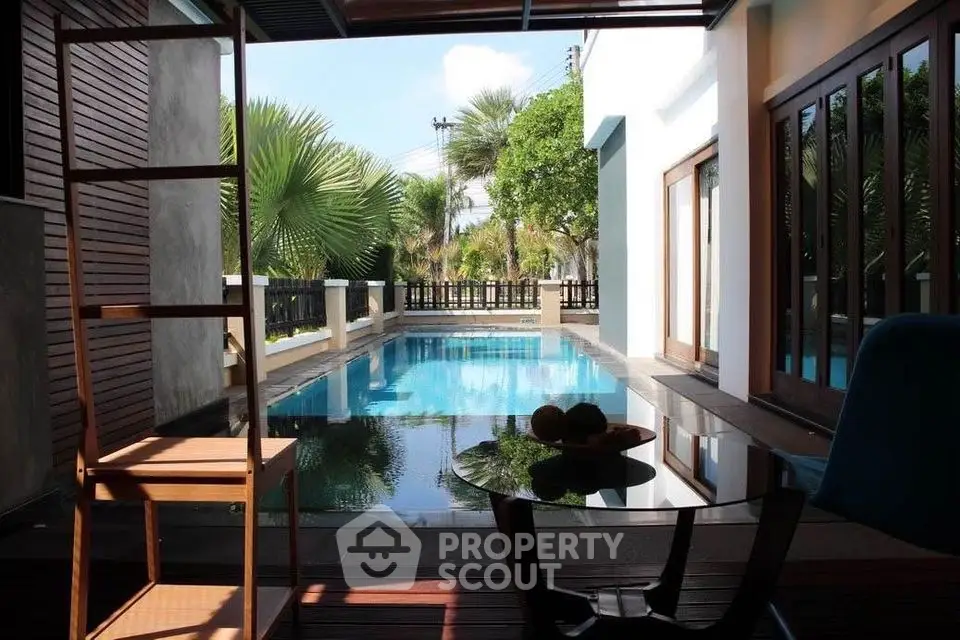 Luxurious private pool view from modern patio with tropical landscaping