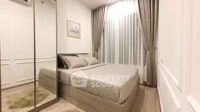 Modern bedroom with mirrored wardrobe and elegant curtains in a cozy apartment.