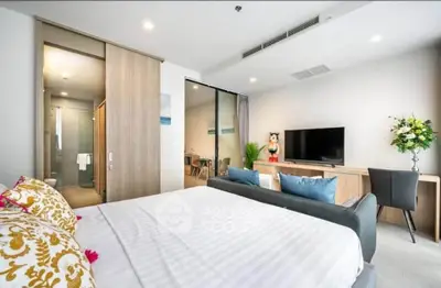 Modern bedroom with stylish decor, featuring a cozy bed, TV, and elegant furnishings in a bright, inviting space.