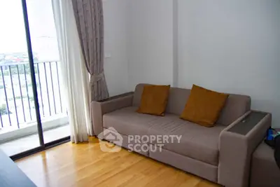 Cozy living room with modern sofa and balcony view in a stylish apartment.
