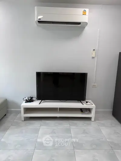 Modern living room with sleek TV setup and air conditioning unit, perfect for comfortable living.