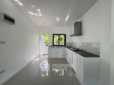 Modern kitchen with sleek black countertops and ample natural light