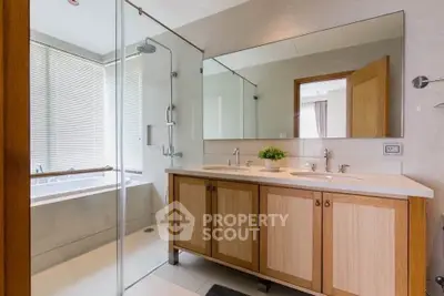 Modern bathroom with dual sinks and glass shower enclosure