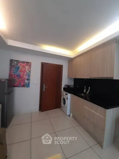 Modern kitchen with sleek cabinets and washing machine in a compact layout.
