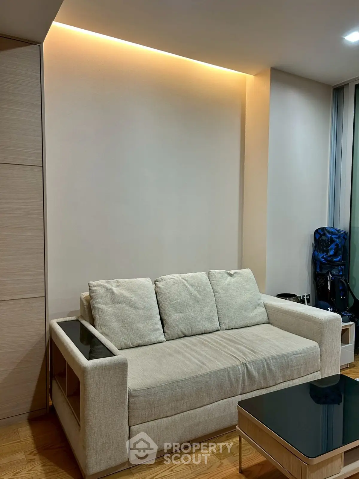 Modern living room with cozy beige sofa and sleek glass coffee table