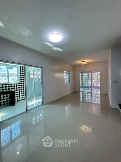 Spacious modern living room with glossy floors and ample natural light
