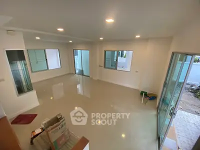 Spacious unfurnished living room with large windows and tiled flooring in modern home