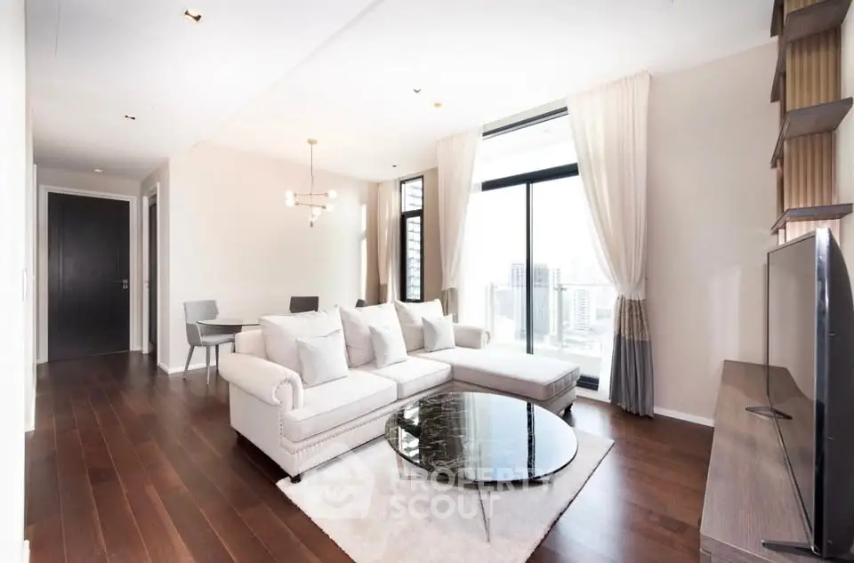 Luxurious modern living room with elegant decor and stunning city view, featuring a cozy sofa and chic dining area.
