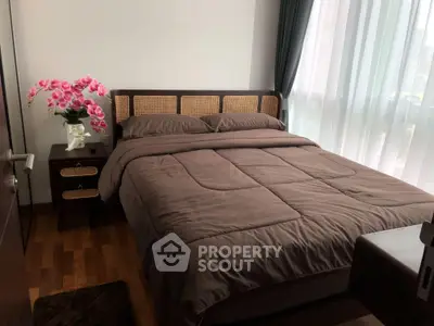 Cozy bedroom with elegant decor and natural light, featuring a stylish bed and wooden flooring.