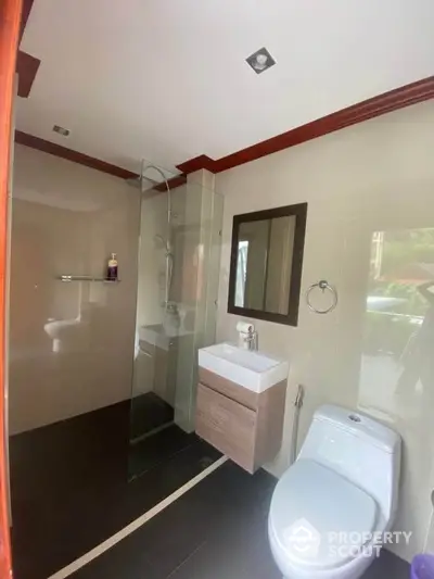 Modern bathroom with glass shower and sleek fixtures in a contemporary home.