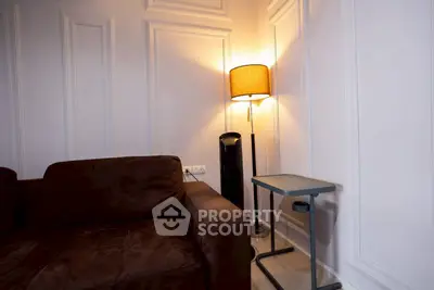 Cozy living room corner with stylish brown sofa and elegant floor lamp