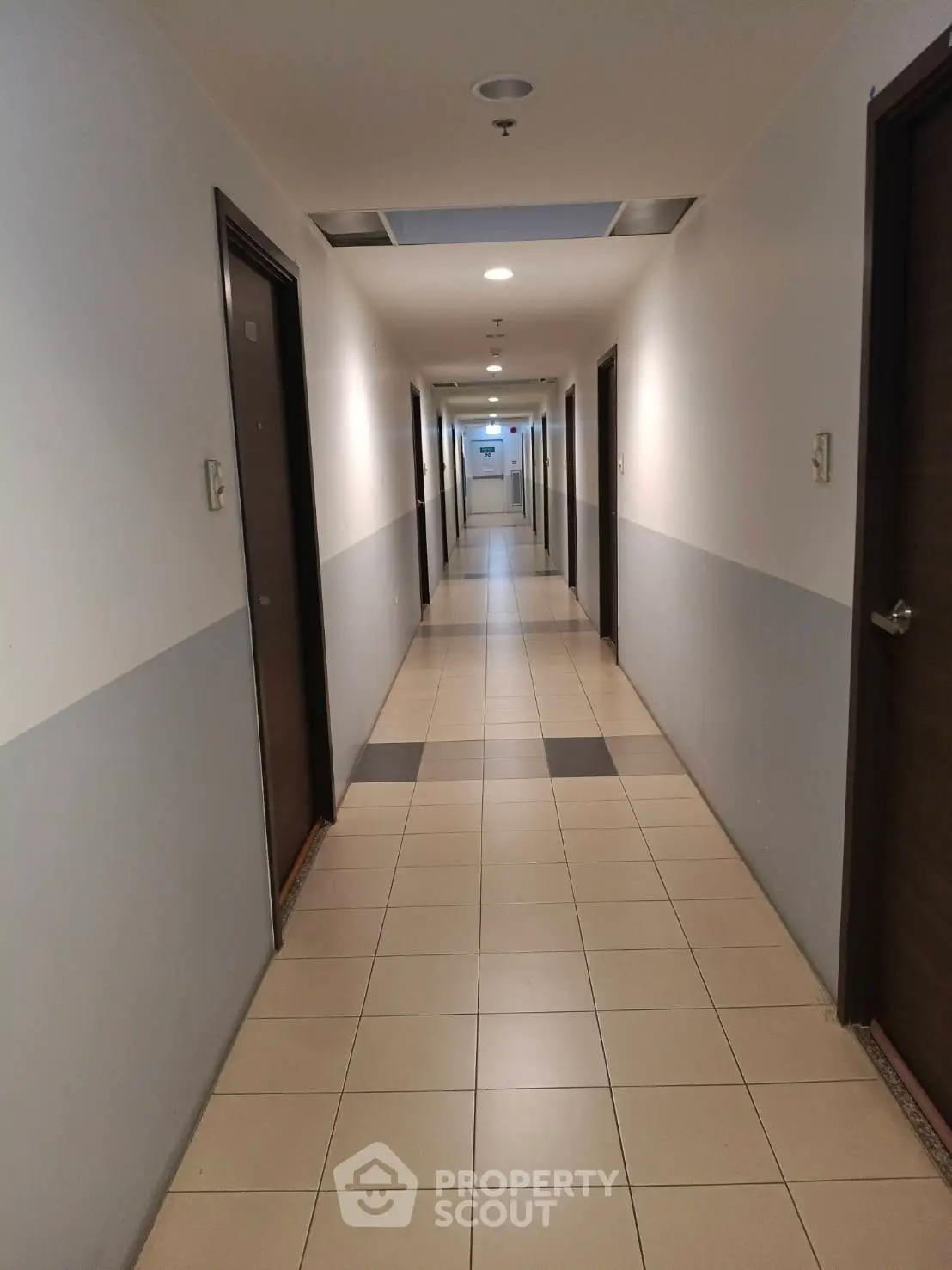 Spacious apartment hallway with tiled flooring and modern lighting