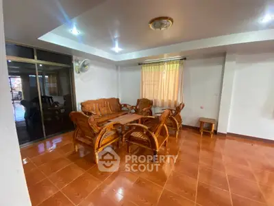 Spacious living room with wooden furniture and large windows, perfect for family gatherings.
