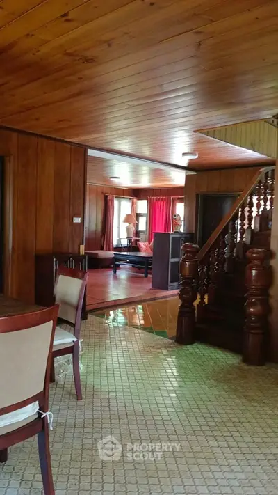 Charming wooden interior with staircase and dining area, perfect for cozy living.