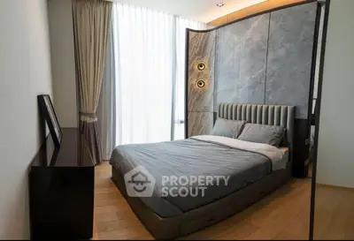 Luxurious modern bedroom with elegant decor and large windows for natural light.