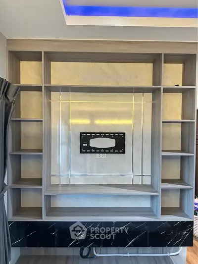 Modern living room with stylish built-in shelving and TV mount, featuring elegant marble accents.