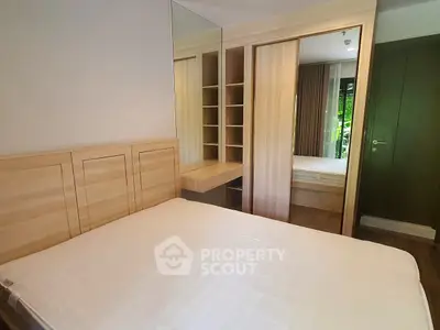 Spacious bedroom with mirrored wardrobe and wooden accents
