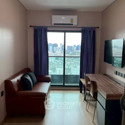 Modern living room with city view, featuring a cozy sofa and work desk, ideal for urban living.