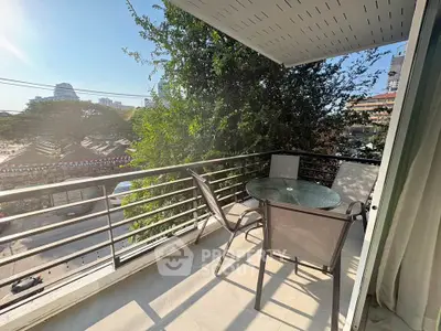 Charming balcony with outdoor seating and lush greenery, perfect for relaxation and enjoying city views.