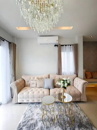 Luxurious living room with elegant chandelier and plush sofa in modern apartment.