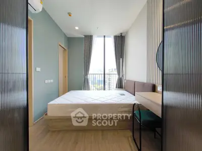 Modern bedroom with large window and stylish decor in a high-rise apartment.