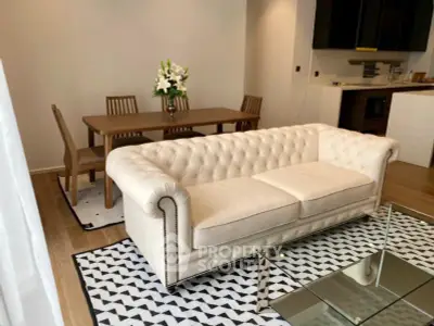 Elegant living room with plush white sofa, modern dining set, and stylish decor in a contemporary apartment.