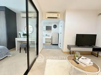 Modern living room with open layout, stylish furniture, and sleek kitchen area in a contemporary apartment.